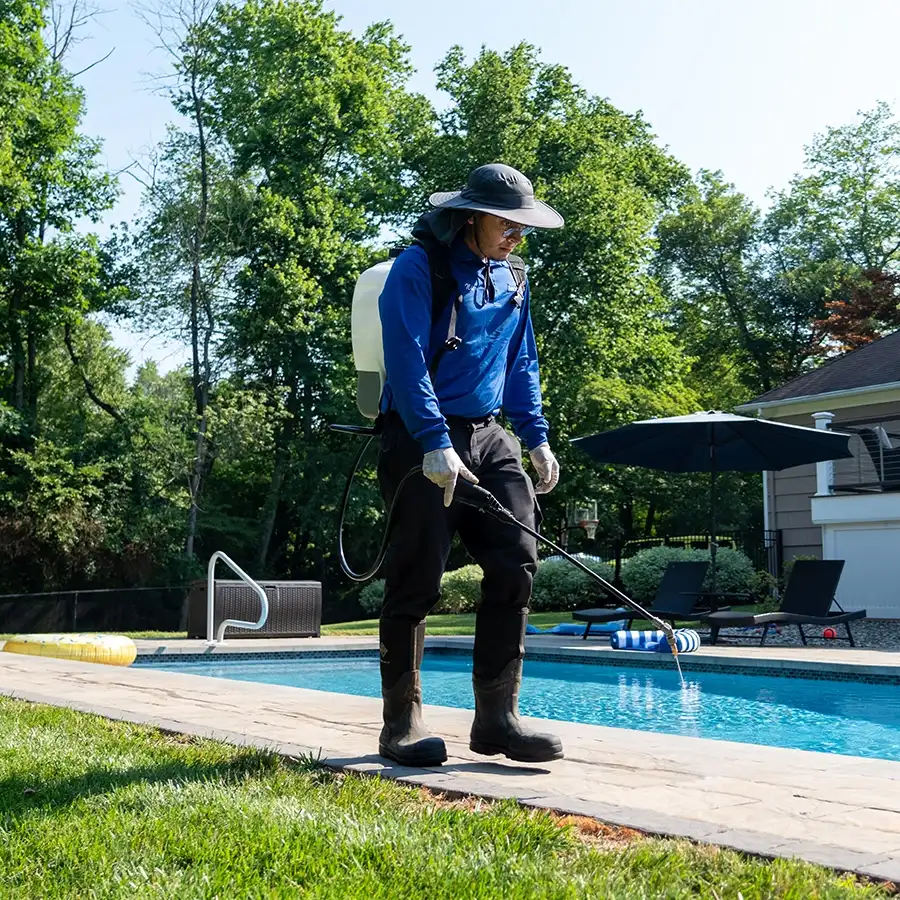 Professional lawn care and pest control service treating a healthy green lawn in Basking Ridge, NJ to prevent crabgrass and weeds